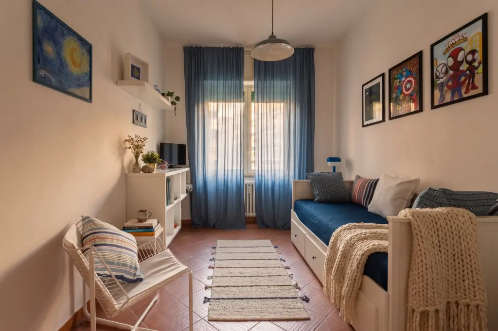 Camera blu per bambini con divano letto e area giochi